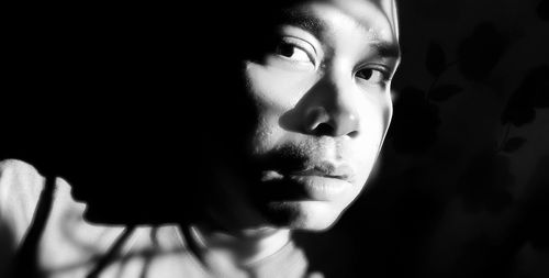 Close-up portrait of beautiful young woman over black background