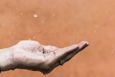 Close-up of water splashing on human palm