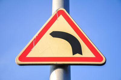 Low angle view of road sign against clear sky