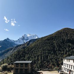 Buildings against mountain range against sky