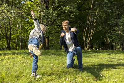 Father teaches little son self defense, fighting in park, meadow. fatherhood, child care. father's