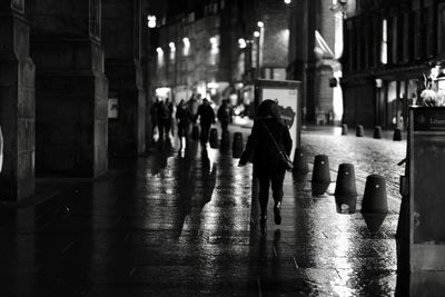 People walking on illuminated city at night