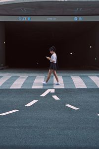 Full length of woman standing on road