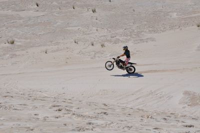 Man riding motorcycle on sand