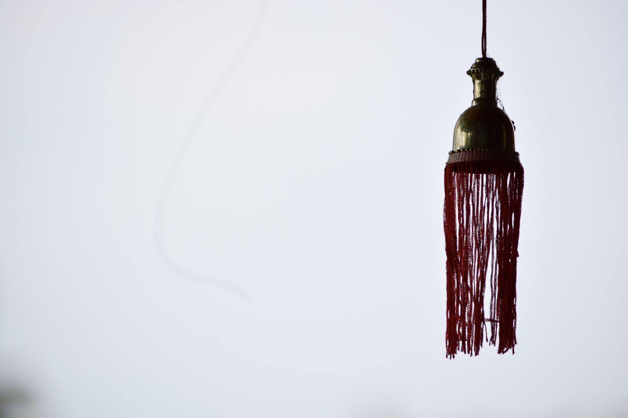 CLOSE-UP OF WHITE BELL HANGING AGAINST WALL