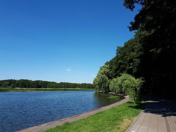 Scenic view of lake against clear blue sky