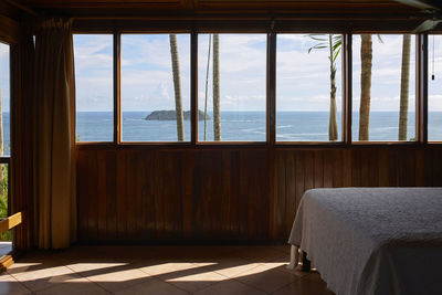 Scenic views of the sea from inside the wooden bedroom through the windows