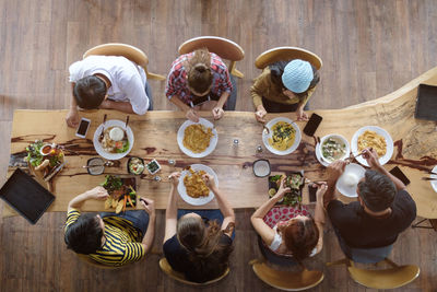 High angle view of people sitting on table