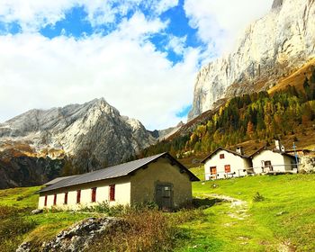 Houses by mountain against sky