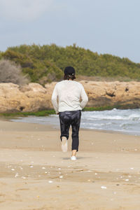 Rear view of woman running on beach