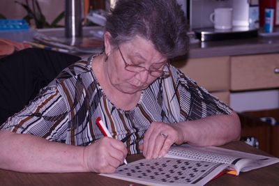 Woman writing on book at home