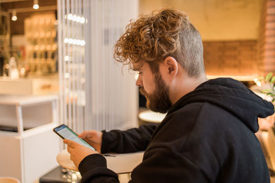 Side view of woman using mobile phone in office