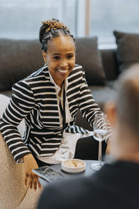 Smiling businesswoman wearing striped jacket sitting during business conference