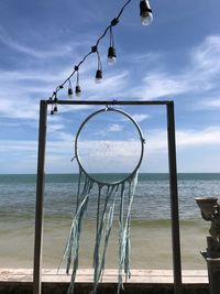 Close-up of clothes hanging on beach against sky