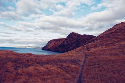 Scenic view of sea and mountains against sky