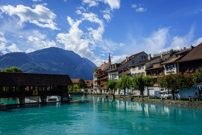 View of swimming pool by buildings against sky