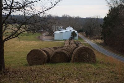 Hay bales on field against sky