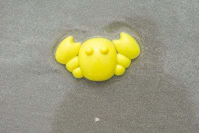 High angle view of yellow toy on sand