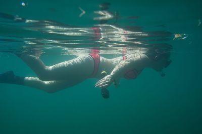 Woman wearing scuba mask while swimming in sea