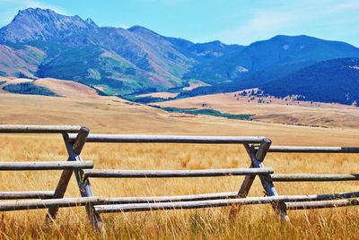 Fence on field against mountains