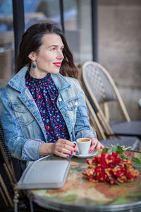 Attractive woman with long brunette hair sitting in the street cafe