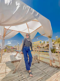 Low angle view of woman standing against sky