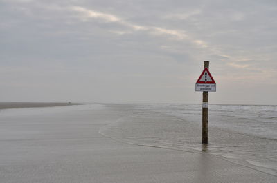 Lifeguard hut on beach against sky