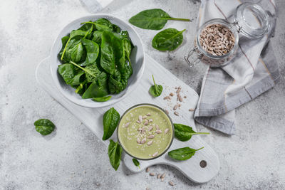 Glass of homemade healthy green smoothie with fresh baby spinach