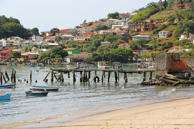 Houses on beach against buildings in town