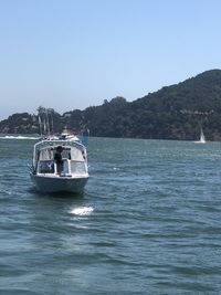 Boat sailing in sea against clear sky