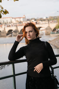 Portrait of woman standing against water