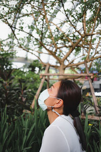 Rear view of woman holding plants