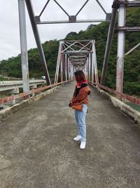 Rear view of woman walking on bridge