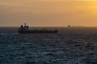 Ship sailing on sea against sky during sunset