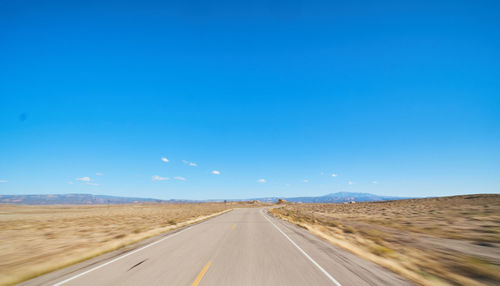 Empty road along countryside landscape