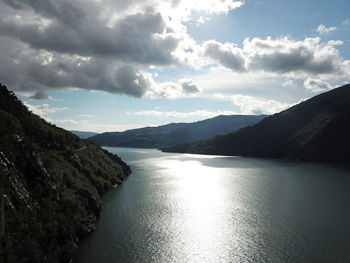 Scenic view of river amidst mountains against sky