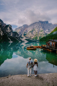 Rear view of people on lake against mountains