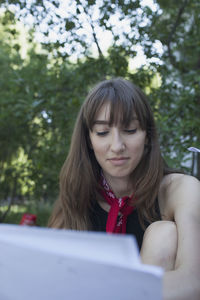 A young woman behind a piece of paper