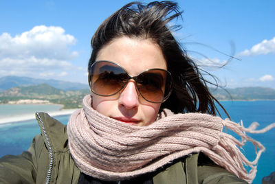 Portrait of young woman wearing sunglasses against sky