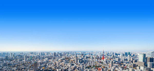 High angle view of modern buildings against blue sky