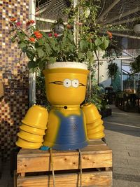 Close-up of yellow toy by potted plants