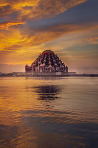 Built structure in sea against cloudy sky
