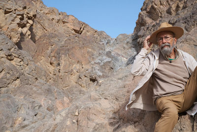 Side view of man standing against rock formations