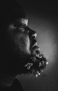 Close-up of young man looking away against black background