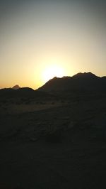 Scenic view of desert against clear sky during sunset