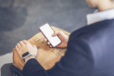 Midsection of man using mobile phone