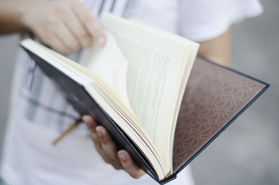 Midsection of man holding book