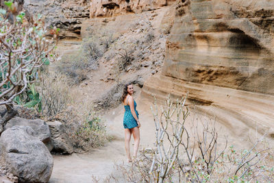 Rear view of woman standing on rock formations