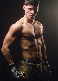 Young man looking away against black background