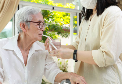 Midsection of woman drinking wine in cafe